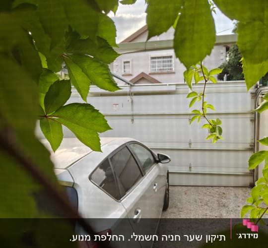 שער חשמלי סגור ליד רכב חונה